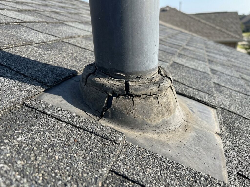 Cracked rubber plumbing vent boot on an asphalt shingle roof, a common source of roof leaks